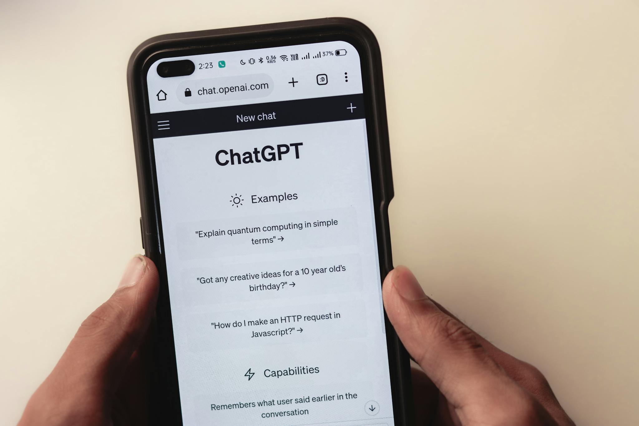 Webpage of ChatGPT, a prototype AI chatbot, is seen on the website of OpenAI, on a smartphone. Examples, capabilities, and limitations are shown.